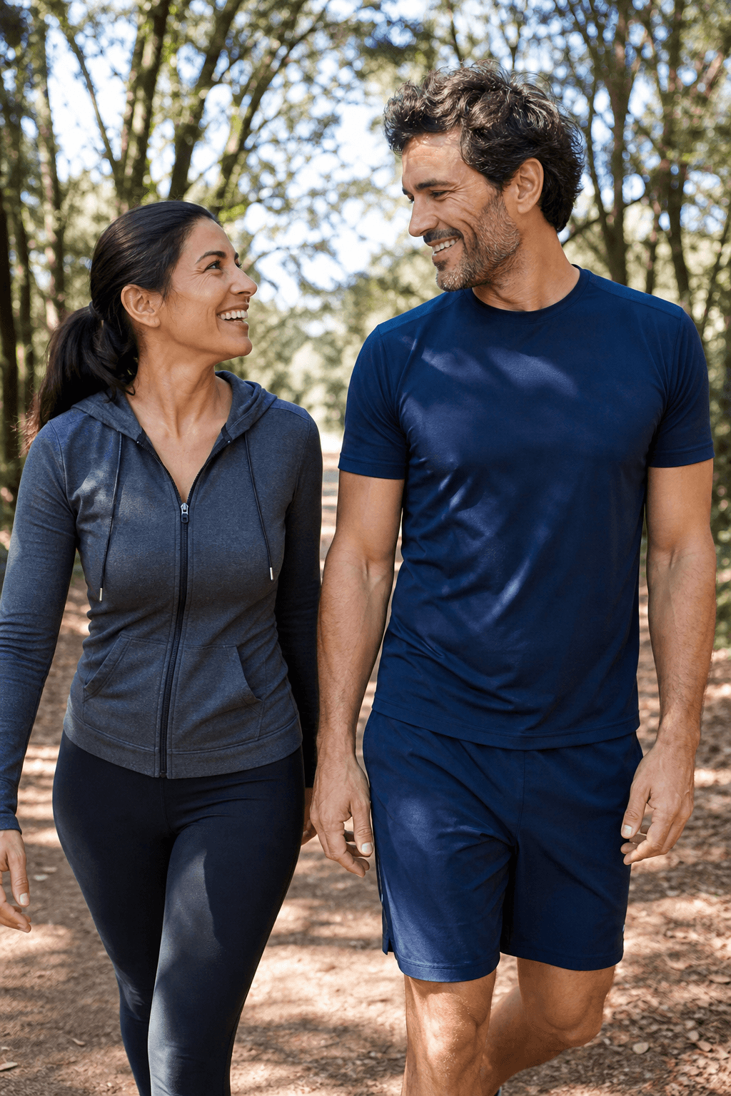 Couple in their late 30s walking together on a sunlit forest trail